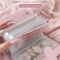 Photo d'un planner d'épargne rose sur un bureau, décoré avec des accessoires de bureau colorés.